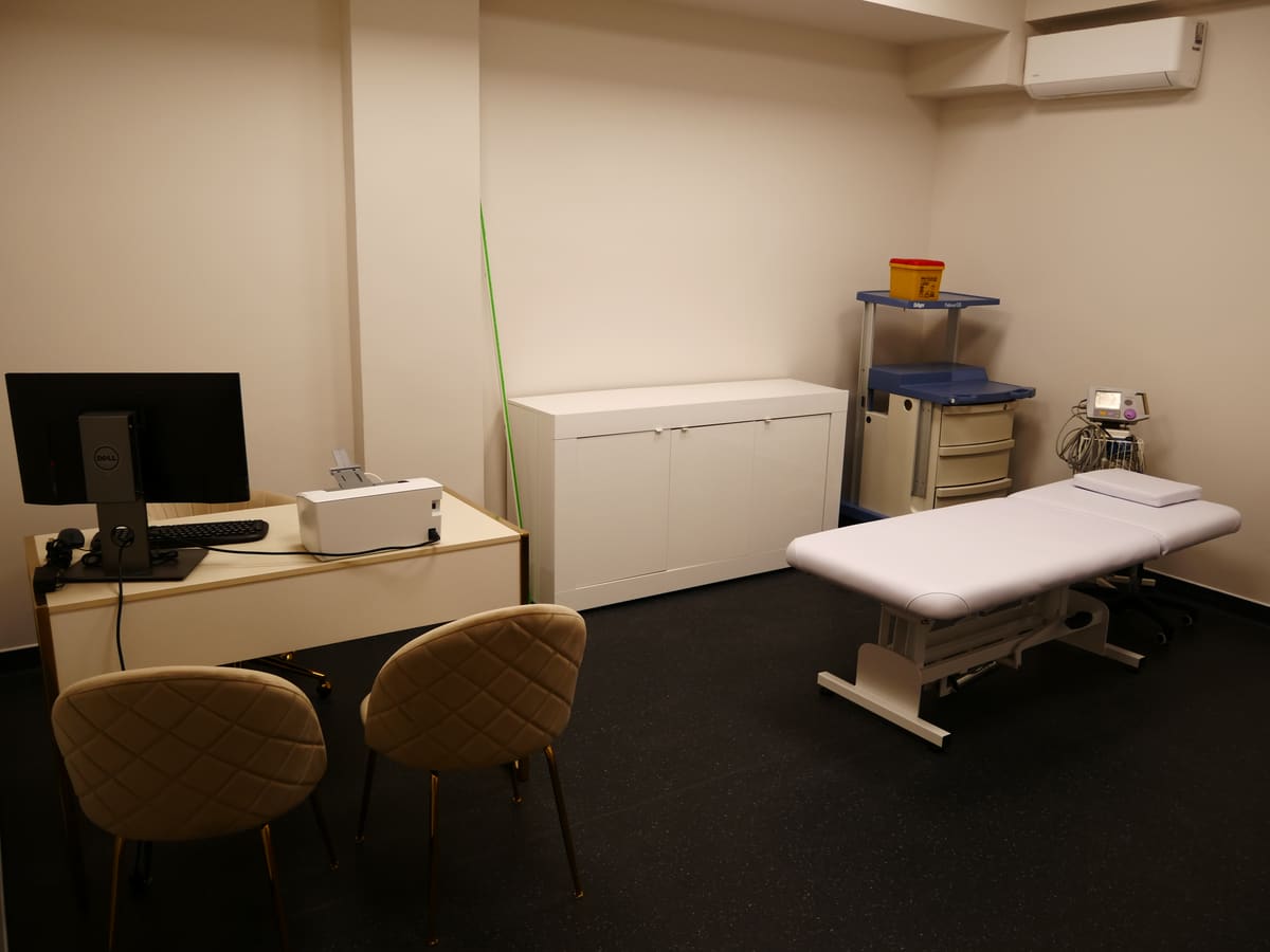 Consultório médico da AC CLINIC equipado com secretária, marquesa e material clínico.